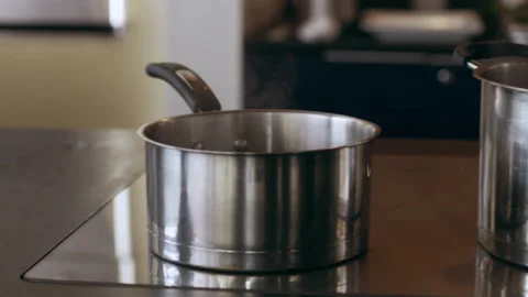 Chef checking a pot of boiling water on a stovetop in interior kitchen with soft Stock Footage 199461344
