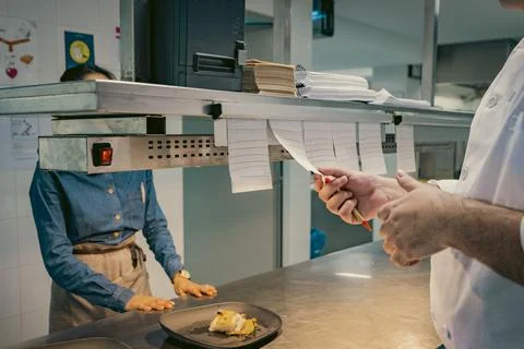 Chef checking restaurant orders in a professional kitchen Stock Photos