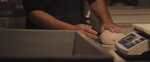 Chef checking the shape of the traditional pizza dough with his hands. Close  Stock Footage 146923084
