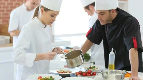 Chef checking on student preparing dish Stock Footage 47772904