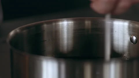 Chef checking the temperature of oil in a hot pan in interior kitchen with soft Stock Footage 199462951