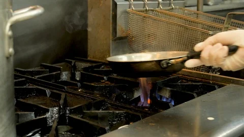 Chef checks pan of vegetables and then moves fryers Stock Footage 94245351