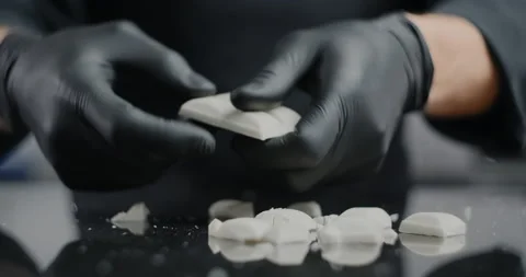 Chef chocolatier breaks white chocolate bar to the small pieces for melting and Stock Footage 132827937