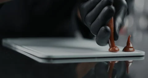 Chef chocolatier makes sweets from melted chocolate with pastry bag in slow Stock Footage 133280332