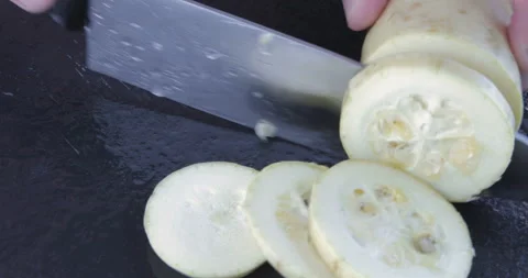 Chef chopped zucchini on a black table with knife Stock Footage 114839192