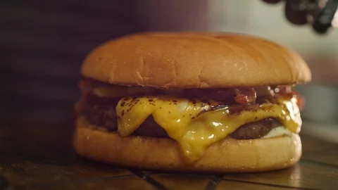 Chef chopping Cheeseburger with Bacon Stock Footage 95189180