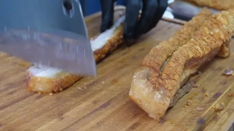 Chef Chopping Delicious Crispy Pork Belly on Wooden Cutting Board Stock Footage 338211817