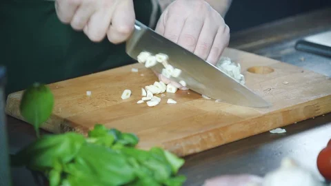 Chef chopping garlic on a cutting board in a restaurant. Prepare food. Stock-Footage 124752786