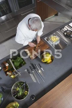 Chef Chopping Kiwi On Board At Commercial Kitchen Counter Stock Photos