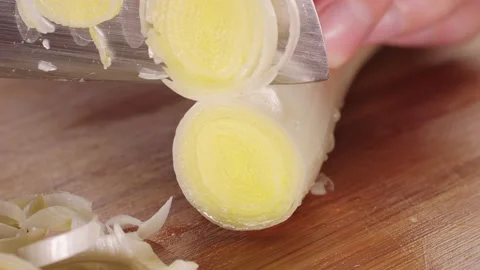 Chef chopping a leek white onion with a knife on the cutting board, macro close Stock Footage 237525974
