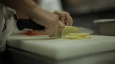 Chef chopping potatoes into slices Stock Footage 90886397