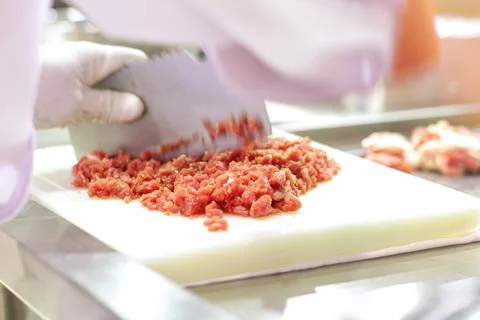 Chef is chopping the raw pork on cutting board with knife to cook in the ki.. Stock Photos