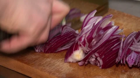 Chef chopping a red onion with a knife on the cutting board. Video stock 247275243
