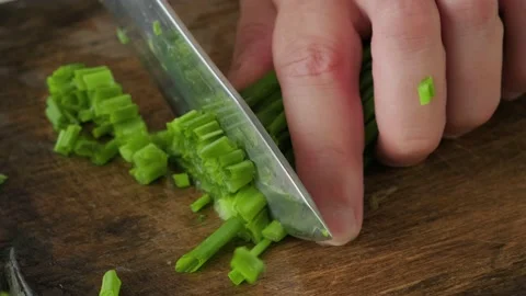 Chef chopping spring onion with knife on wooden board Stock Footage 226140382