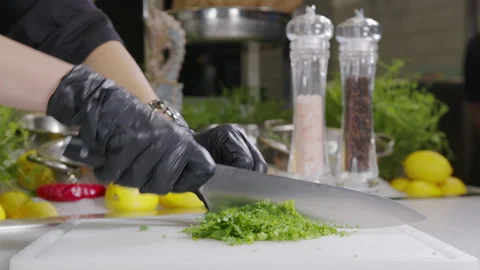Chef chops parsley and dill with a knife on the table, close-up. Stock Footage 144272164