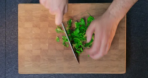 Chef chops parsley on cut board. Chopping parsley, view from above. Stock Footage 231214176