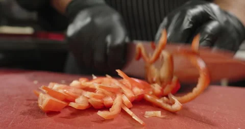 Chef chops red bell pepper on the cutting board. Male hands cut vegetables Stock Footage 265502923