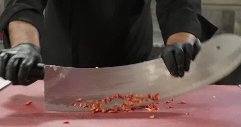 Chef chops red bell pepper on the cutting board with a big knife or axe Stock Footage 275855428