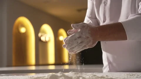 Chef clapping his hands with flour in a professional kitchen Stock Footage 333576497