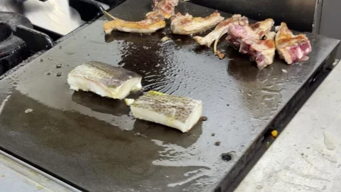 Chef cleaning a hot griddle with water in a professional kitchen 스톡 동영상 344100269