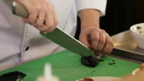 Chef cleans grilled pepper with knife Stock Footage 74716036