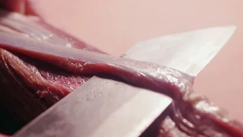 Chef cleans raw meat and cuts off connective tissue and surface membrane from a Stock Footage 222213376