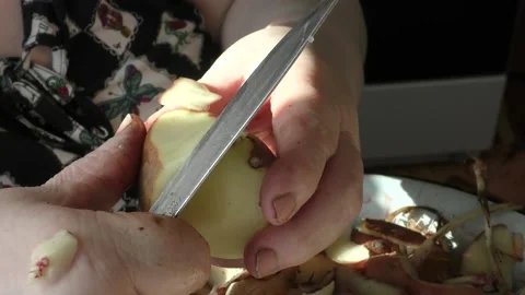 Chef cleans raw potatoes with a knife Video stock 170172660