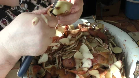 Chef cleans raw potatoes with a knife Stock Footage 170575104