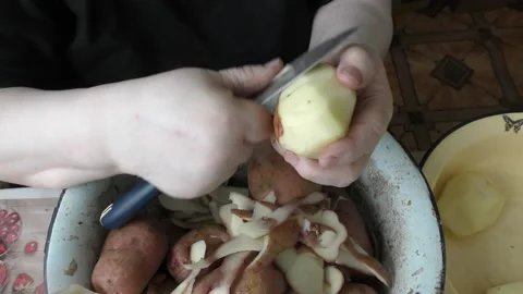 Chef cleans raw potatoes with a knife Video stock 177160654