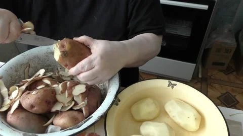 Chef cleans raw potatoes with a knife Stock Footage 177160919