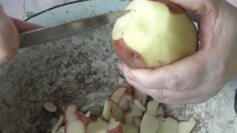 Chef cleans raw potatoes with a knife Stock Footage 202107578