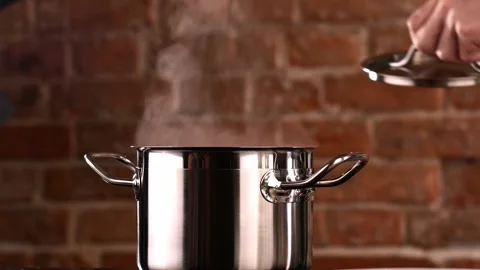 Chef close the lid of the Pan. White Clouds of steam rise from under the raised Stock Footage 151119260