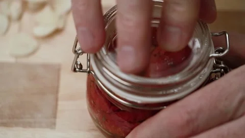 Chef closes finished sun dried tomatoes in a glass jar with a hook lock. macro. Stock-Footage 253837355