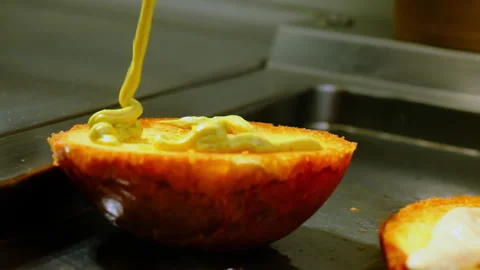 Chef coats surface of toasted hamburger bun with sauce Video stock 325024680