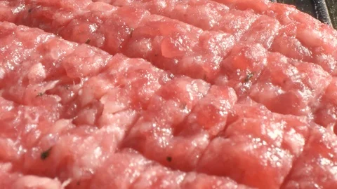 Chef cook in black gloves forms a cutlet for cooking with a fork on the cutlet Stock Footage 115774796