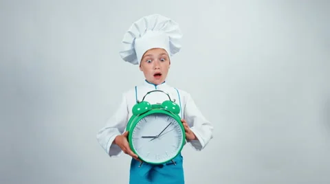 Chef cook child 7-8 years holding alarm clock which ringing standing isolated Vidéo 67169051