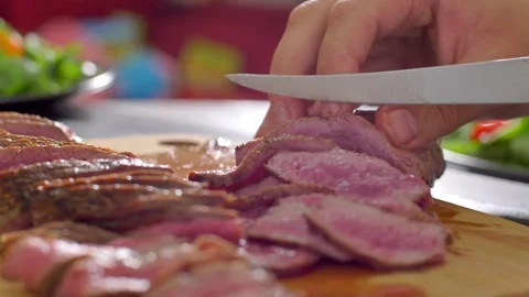 Chef cook cut beef with a knife on wooden board mid roasting Stock Footage 255979119