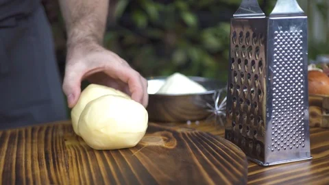 Chef cook cutting with knife cheese on wooden table. Cutting fresh cheese for Stock Footage 98770517