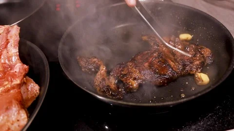 Chef cook fried meat steak in pan, steam from the dish Stock Footage 115286516