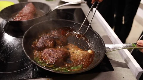 Chef cook fried meat steak in pan Stock Footage 115287727