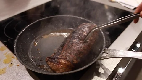Chef cook fried meat steak in pan, steam from the dish Stock Footage 115288225