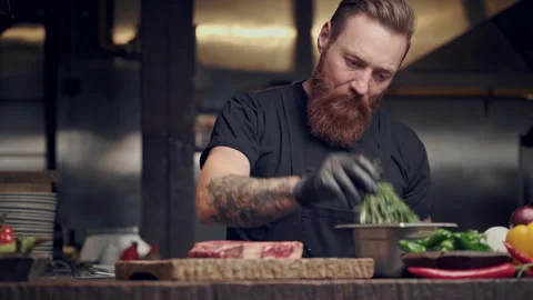 Chef cook preparing raw steak. Using oil and rosemary leaves. Video stock 151468560