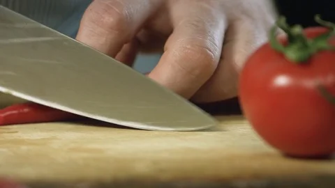 Chef cook professionally cutts chilli pepper with a chefs knife on cutting board Stock Footage 76952951