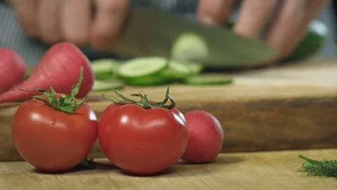 Chef cook professionally slicing a cucumber with a chef's knife on cutting board Stock Footage 76878166