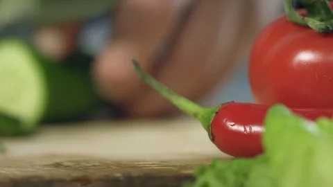 Chef cook professionally slicing a cucumber with a chef's knife on cutting board Stock Footage 76884288
