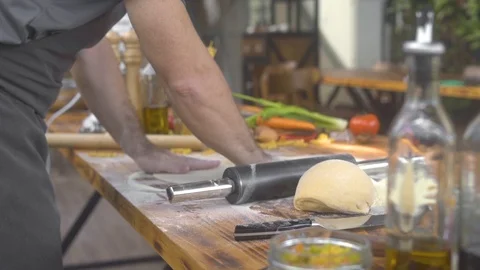 Chef cook sprinkling flour on pizza dough while rolling with roller pin. Man Stock Footage 108315212