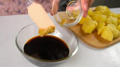 Chef cooking adding mustard to soy sauce marinade for potatoes on kitchen. Stock Footage 317171029
