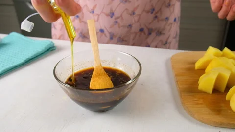 Chef cooking adding olive oil to soy sauce marinade for potatoes on kitchen. Stock Footage 317172192
