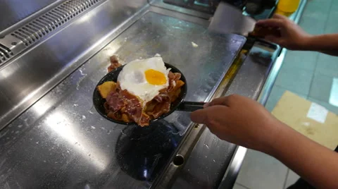 Chef cooking bacon and fried eggs. Stock Footage 64711514