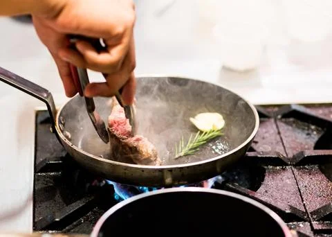 Chef cooking, Chef preparing food in the kitchen, closeup.. Stock Photos